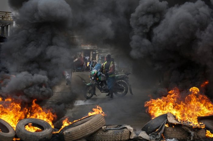 A motorcyclist stopped at a burning barricade set up by opposition supporters in the Kibera slum of Nairobi, Kenya, during the weekly protest on what is now known as Tear Gas Monday.